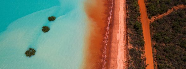 Aerial view of  red sand meeting water at Roebuck Bay, Western Australia