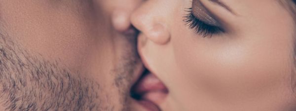 Male and female couple embracing in deep french kiss involving tongue