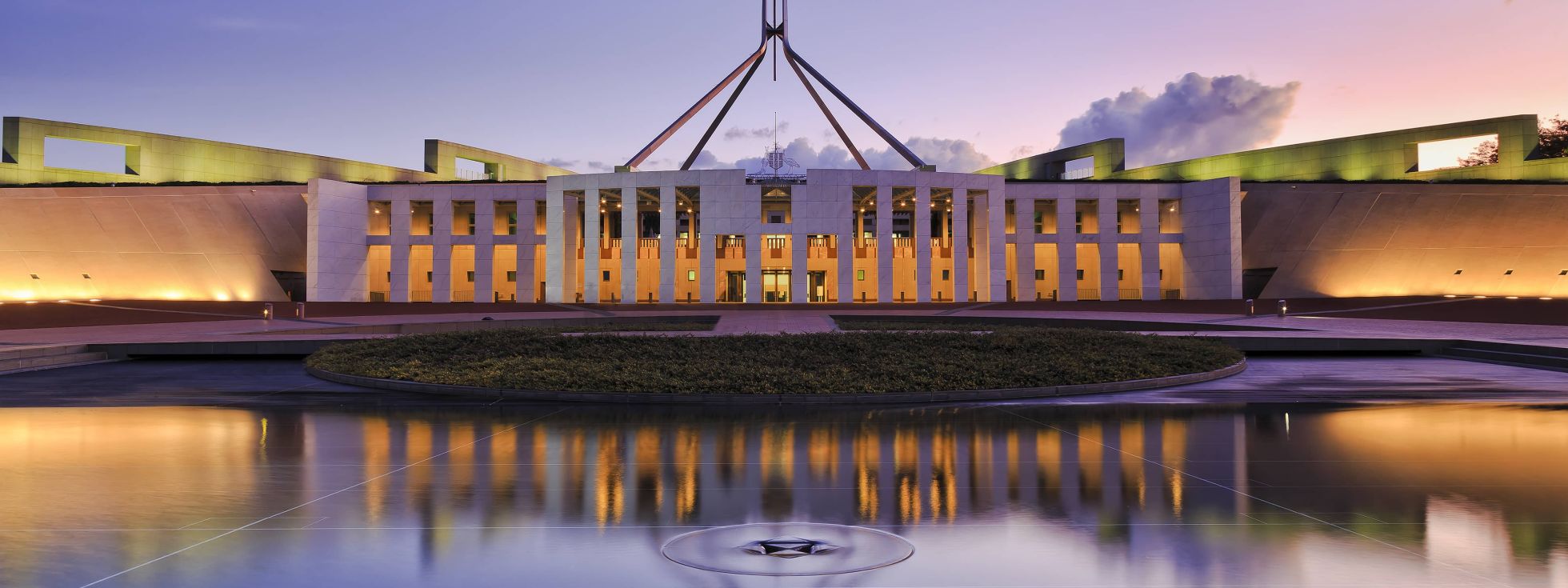 reflection of Canberra Parliament house in fountain pond at sunset